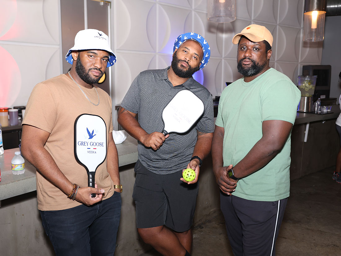 Three black men holding pickleball paddles at Grey Goose event.