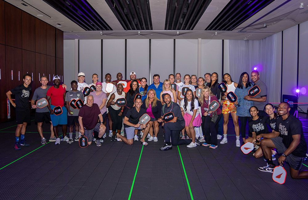 Group photo on glow in the dark pickleball court.