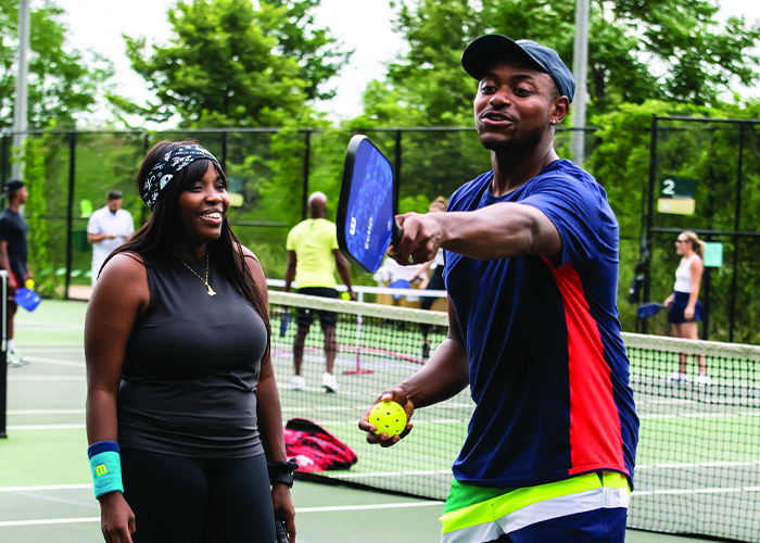 pickleball-event Black pickleball coach teaching the game to new pickleball player.